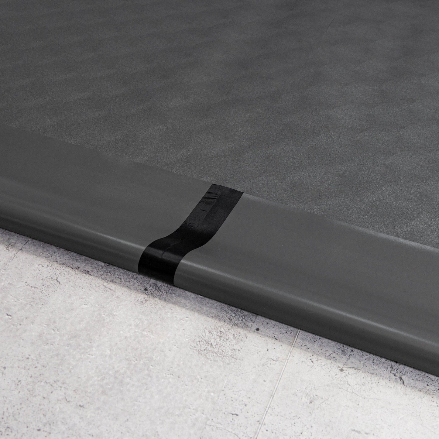 Two pieces of Slate Grey Levant texture vinyl flooring and black seam tape
